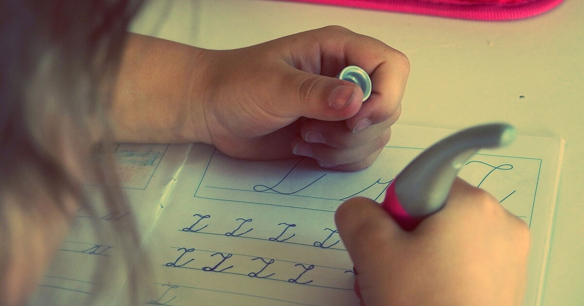 Kind beim Buchstaben schreiben lernen