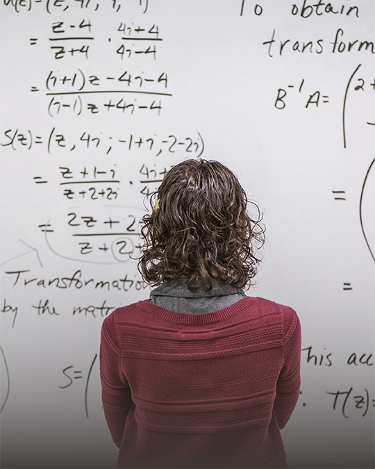 Studentin vor einer Tafel mit mathematischen Formeln