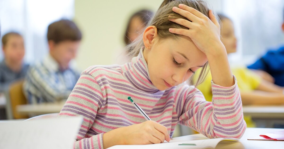  Gruppe von Schulkindern schreibt einen Test im Klassenzimmer