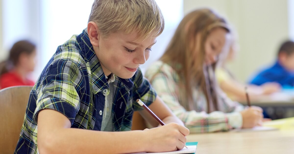 Junge schreibt einen Test im Klassenzimmer